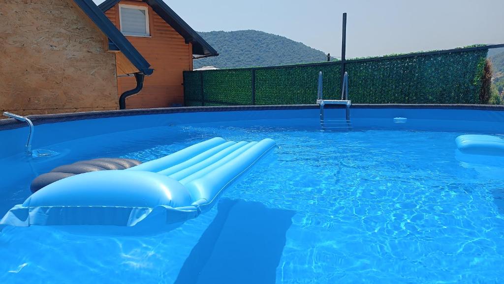 a swimming pool with a blue pool noodle in the water at Sun-Moon Apartment in Zbilje