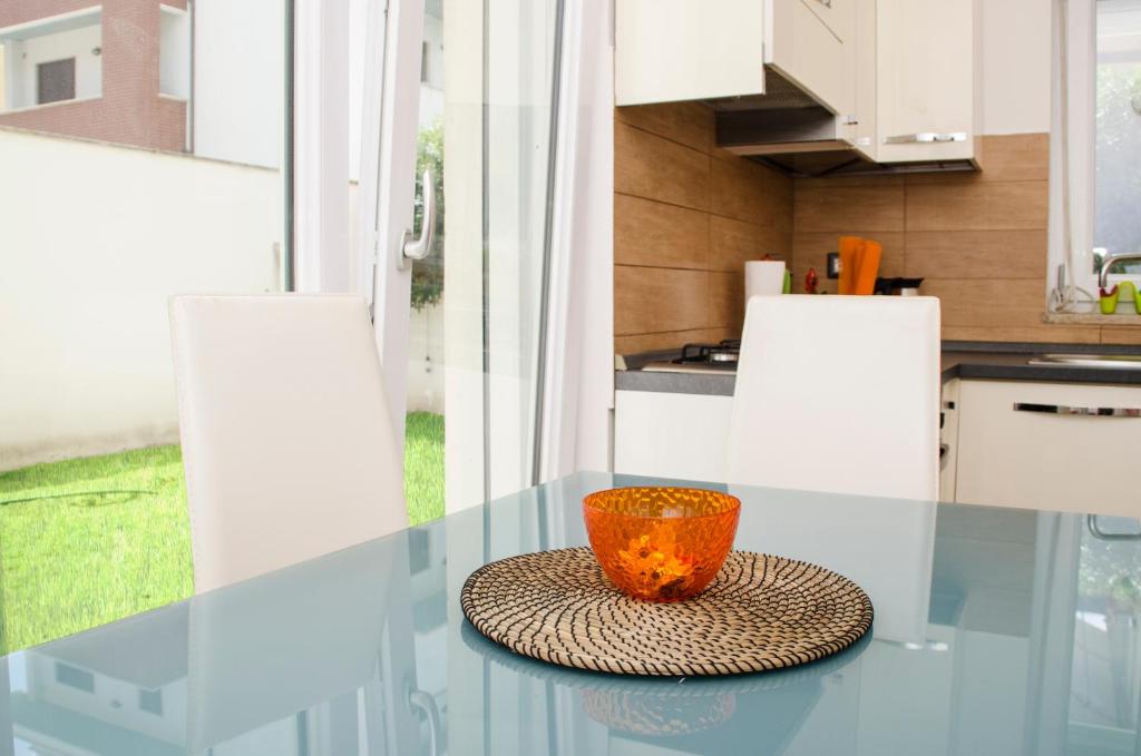 una taza naranja sentada en una mesa de cristal en una cocina en Sun Garden l.t., en Fiumicino
