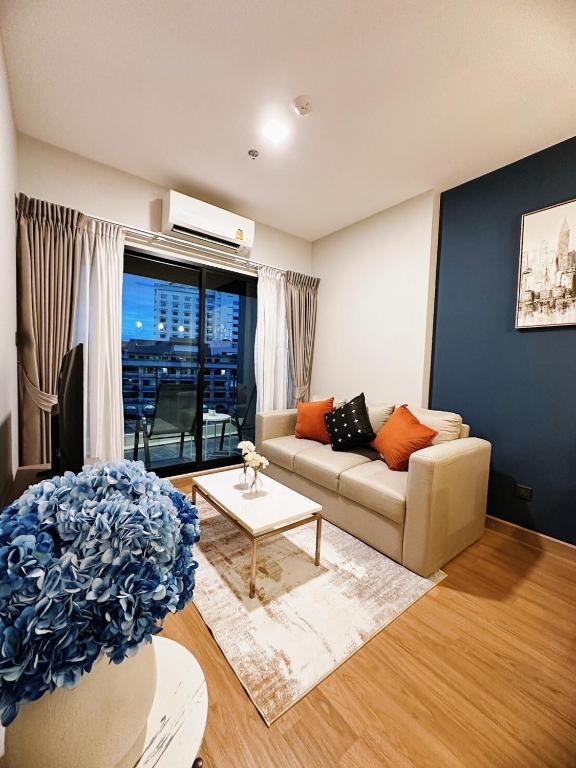 a living room with a couch and a table at Astra sky river five star condo in Chiang Mai
