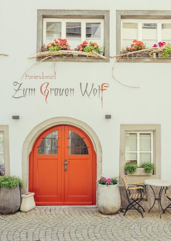 a red door on the side of a building at Feriendomizil "Zum Grauen Wolf" - Exklusive Ferienwohnungen im Herzen der Insel Lindau in Lindau