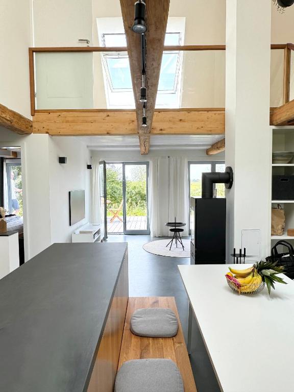a kitchen with a large island in a room at Westertilli Middelhuus - modernes, luxuriöses Wohngefühl in Pellworm