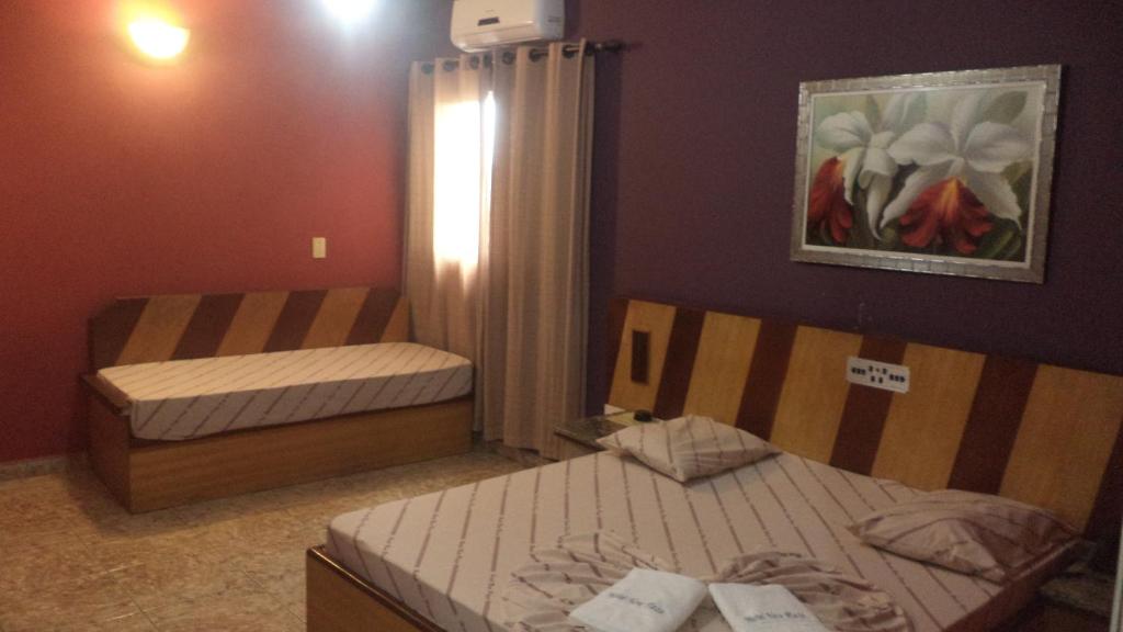 um quarto com duas camas e um quadro na parede em Hotel New Plaza em São Bernardo do Campo