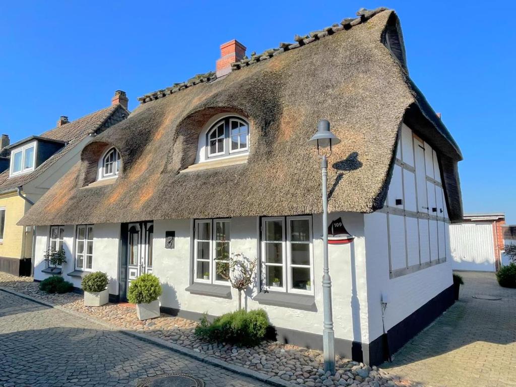 un antiguo edificio blanco con techo de paja en Fischerkate in Massholm, en Maasholm