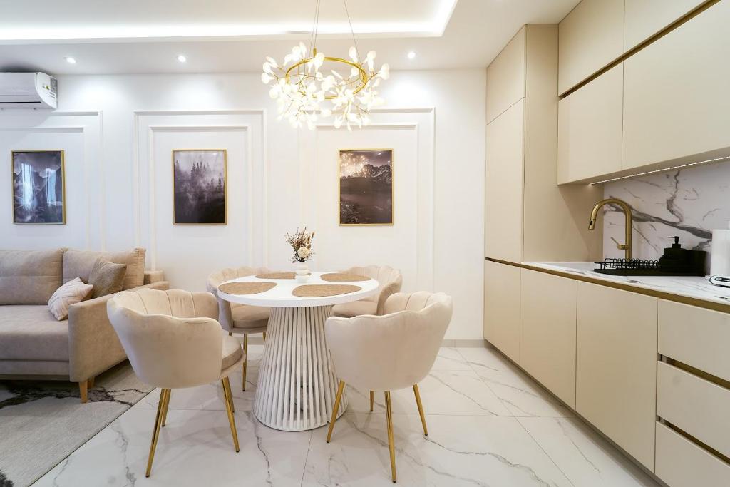 a kitchen and living room with a table and chairs at Polanica Park -LAGUNA - PREMIUM 2 in Polanica-Zdrój