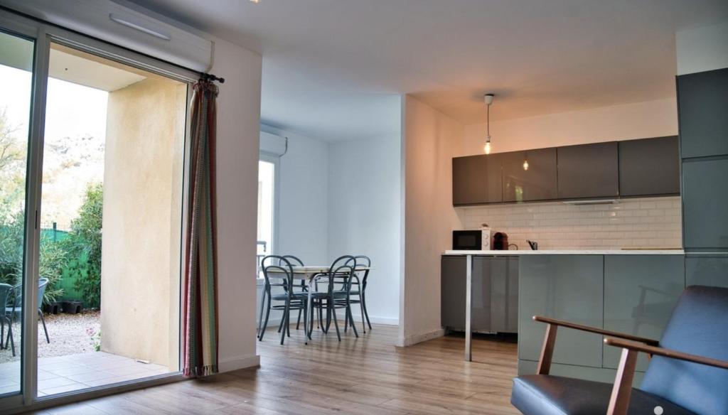 une cuisine et une salle à manger avec une table et des chaises dans l'établissement près Avignon clim parking jardin, aux Angles (Gard)