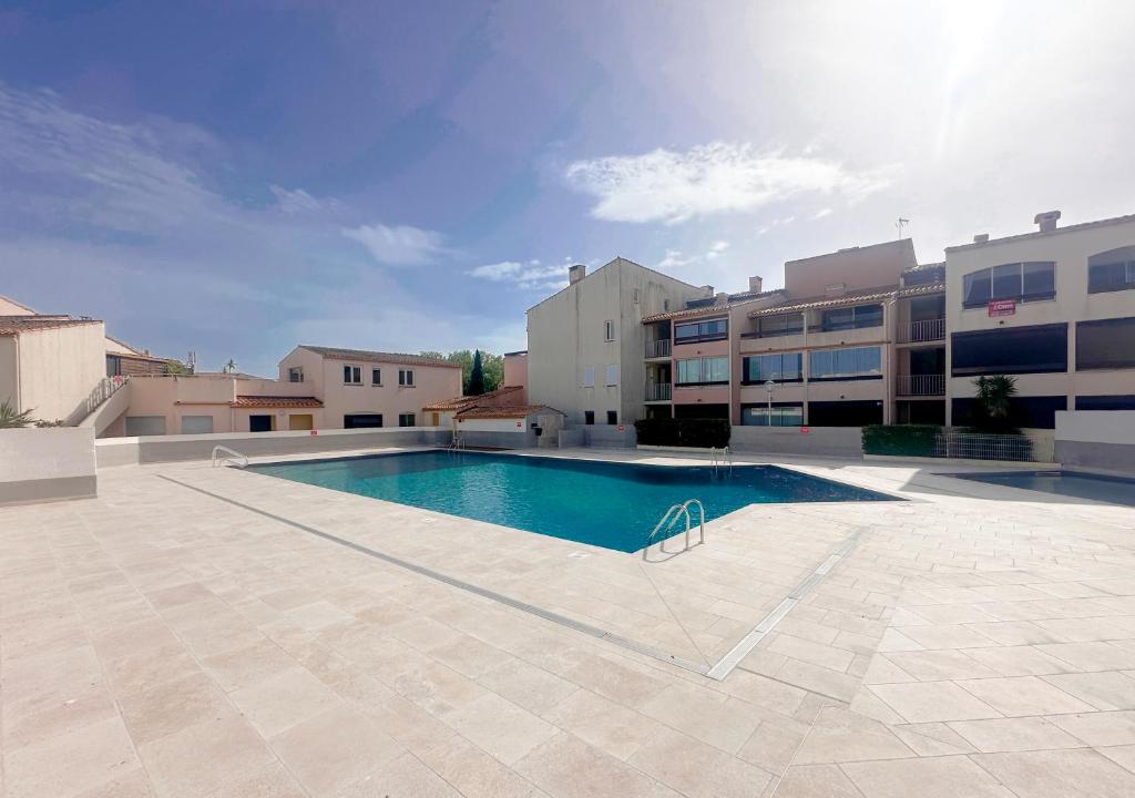 une piscine devant un immeuble dans l'établissement Falea by POM, Terasse, au Cap d'Agde