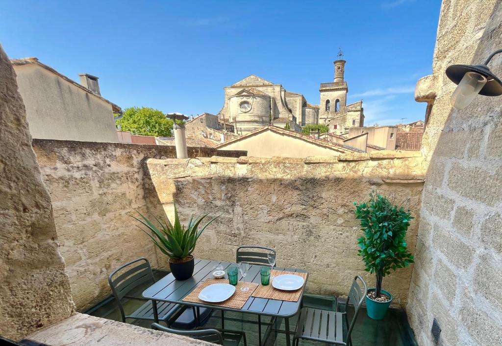 eine Terrasse mit einem Tisch und Stühlen sowie einem Schloss im Hintergrund in der Unterkunft Maison de Roche - Uzès Centre historique La Fenestrelle in Uzès