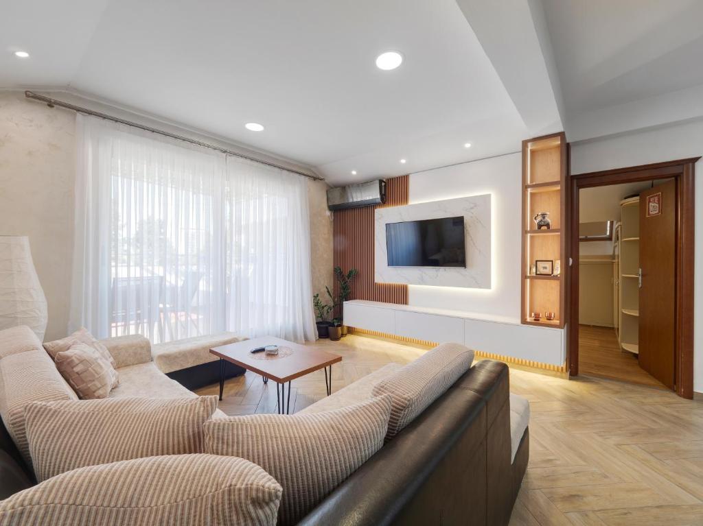 a living room with a couch and a table at Dobrljanin LUX apartment in Budva