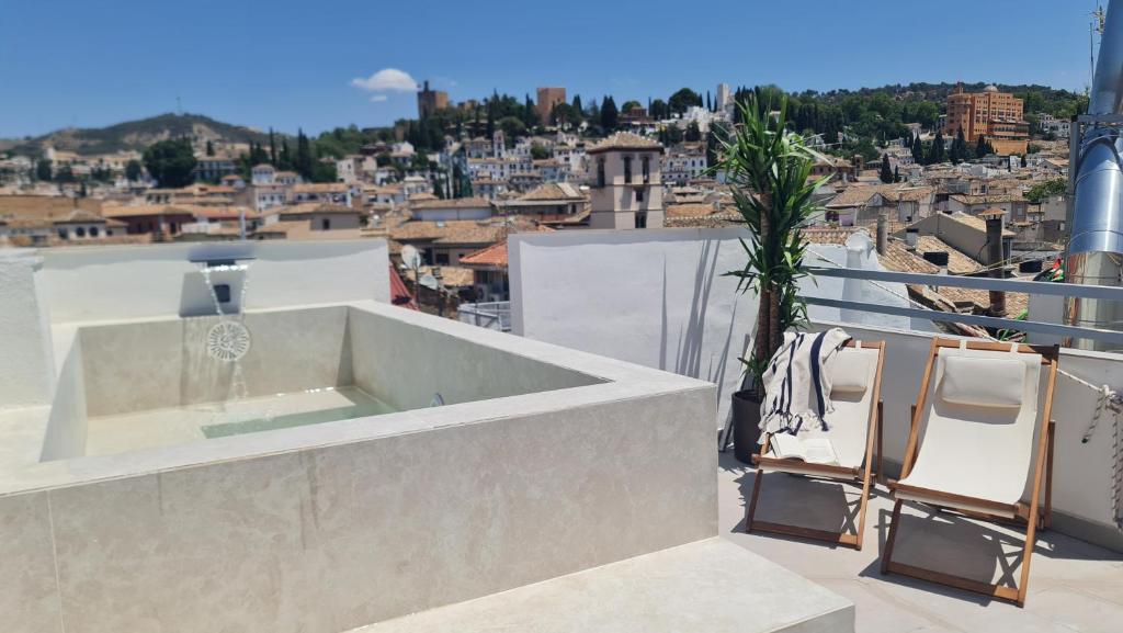bañera en el balcón con vistas a la ciudad en Navas 402 Ático & Pool Alhambra views, en Granada