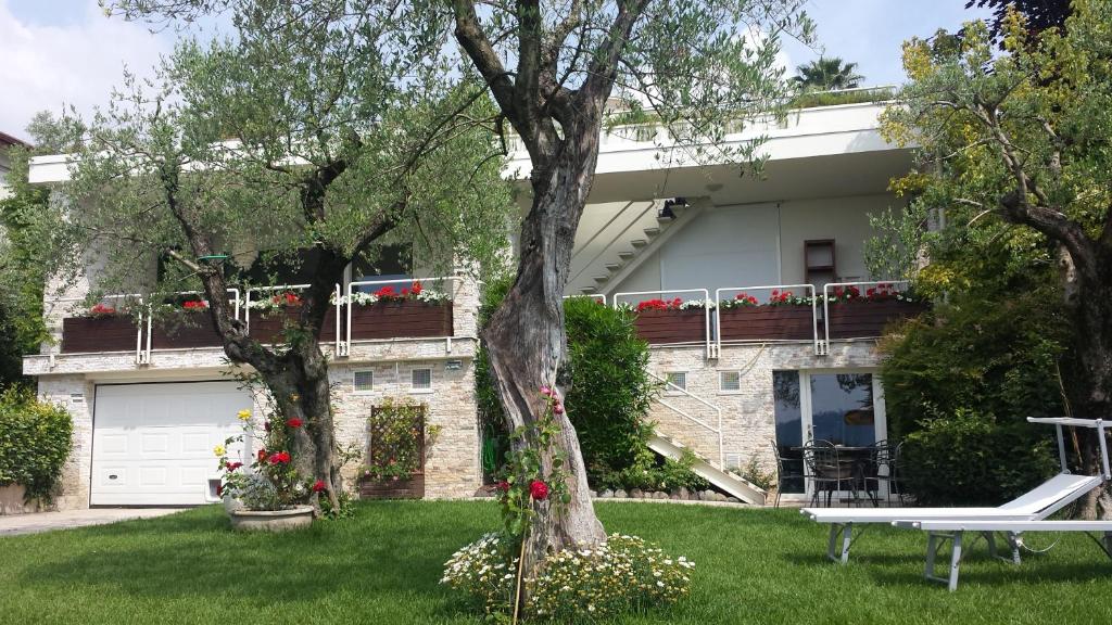 a house with flowers in the yard at Jane's Dream Apartment in San Felice del Benaco
