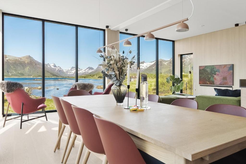 a dining room with a large table and chairs at Seafront Luxury Villa near Henningsvær in Kleppstad