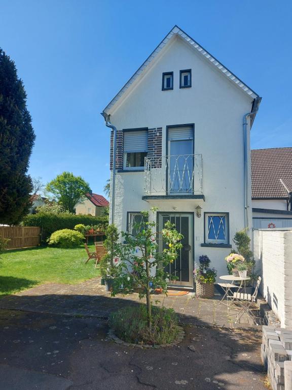 a white house with a tree in front of it at Ferienhaus "Schmale Gisela" bis zu 6 Personen mit Garten und Parkplätzen in Seligenstadt