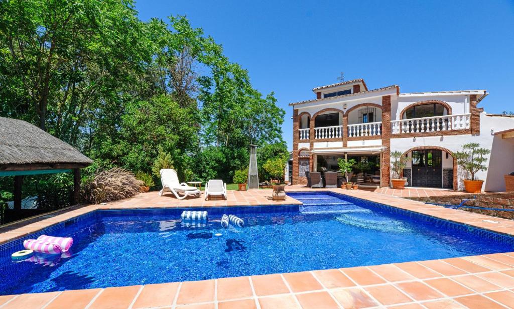 a swimming pool in front of a house at Casa de las Risas B&B in Alhaurín el Grande