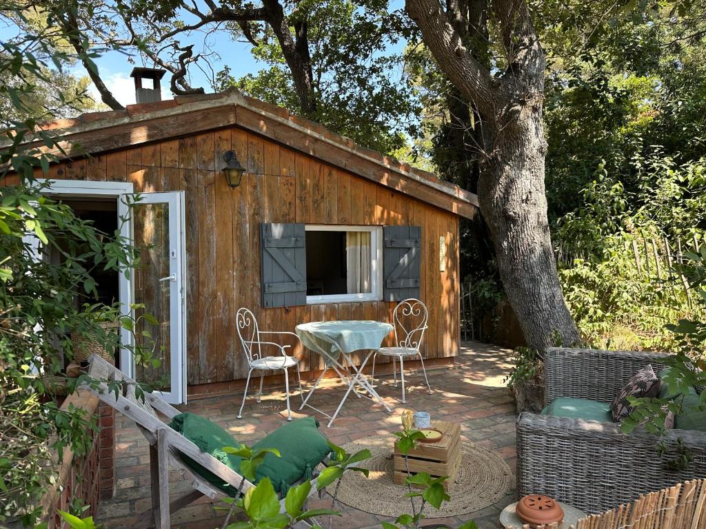 une petite cabine avec une table et des chaises sur une terrasse dans l'établissement Joli studio en pleine nature, à Six-Fours-les-Plages