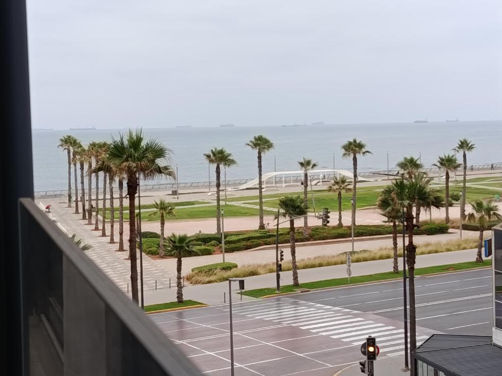 a view of a parking lot with palm trees and the ocean at Studio de charme face corniche de Casablanca in Casablanca