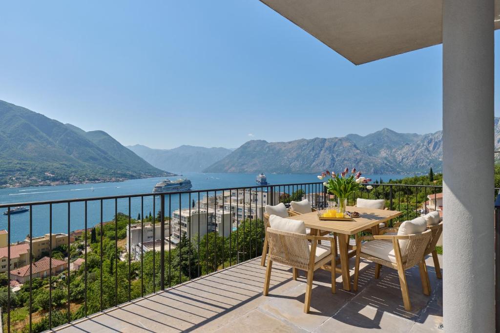 a balcony with a table and chairs and a view of the water at Sea Breeze Residence in Kotor