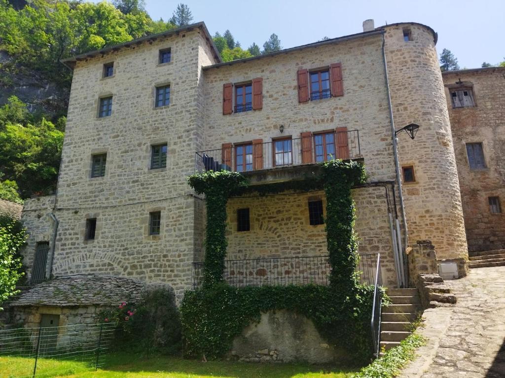 a large brick building with ivy on it at Gîte Le Pigeonnier10P, Ste Enimie,Gorges du tarn, village de Saint Chély du Tarn 