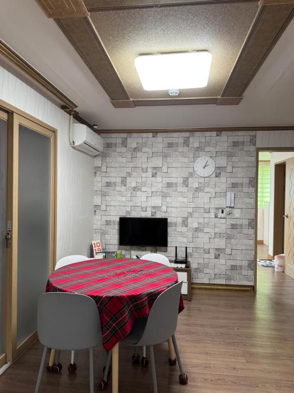 a dining room with a table and chairs and a tv at Suncheon Doran Doran House in Suncheon