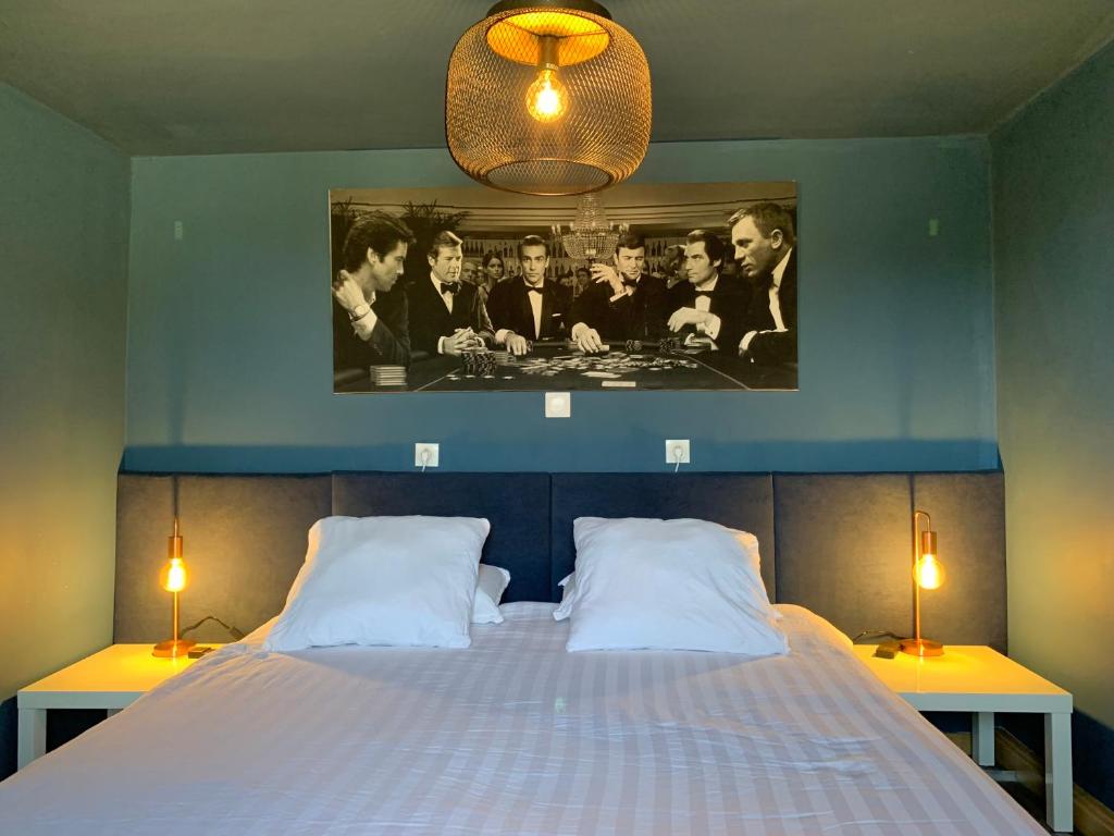 a bedroom with a bed with a picture on the wall at Le 007 Refuge -Rurale gîte élégant piscine privée in Queyssac