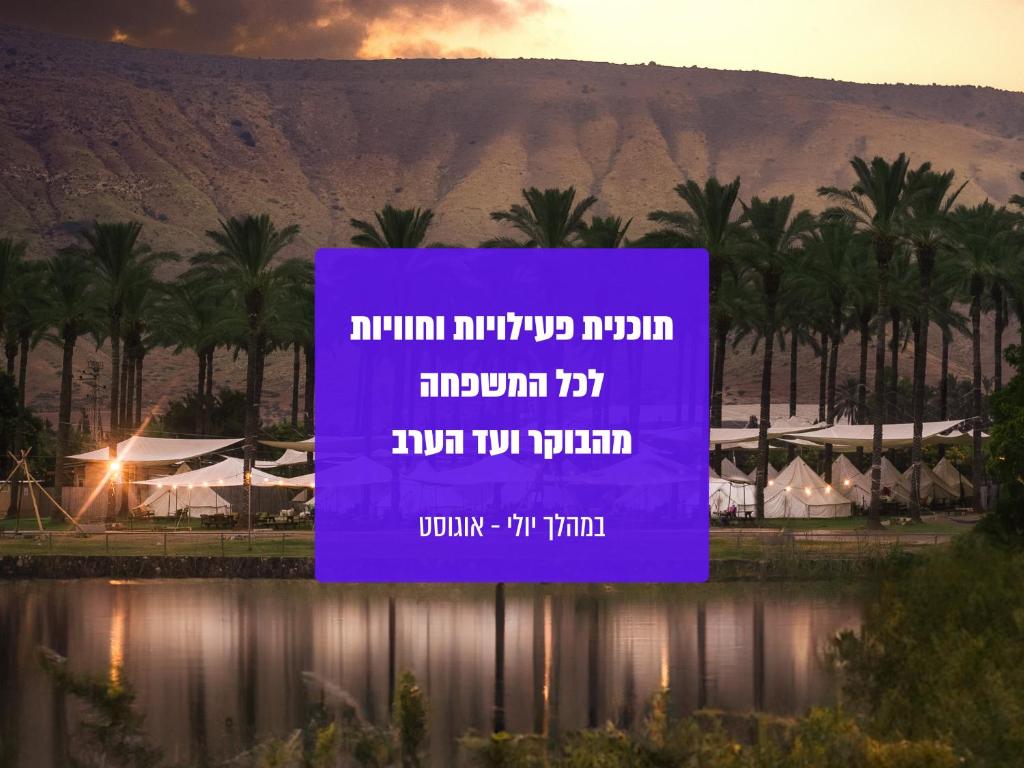 un grande cartello viola davanti a una montagna di גלאמפינג מיא על הכנרת - חוף האון a HaOn