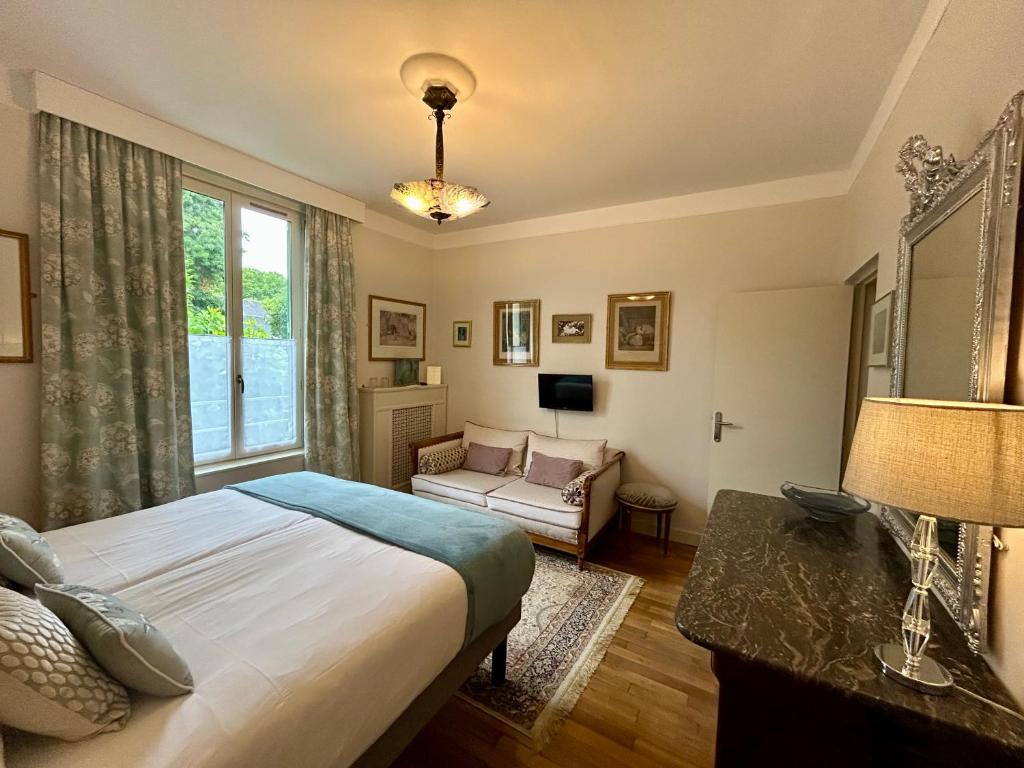une chambre avec un lit, un canapé et une fenêtre dans l'établissement La Villa de Chinon, à Chinon