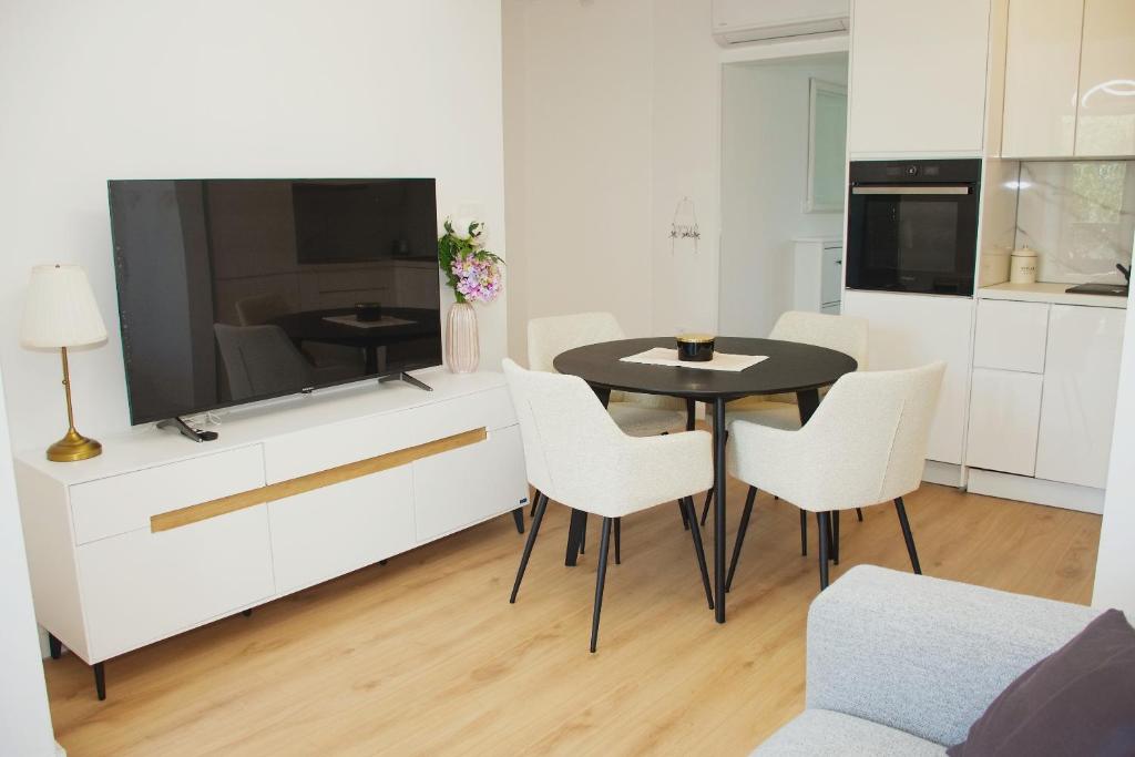 a living room with a table and a large television at Tramonto Suite in Novalja