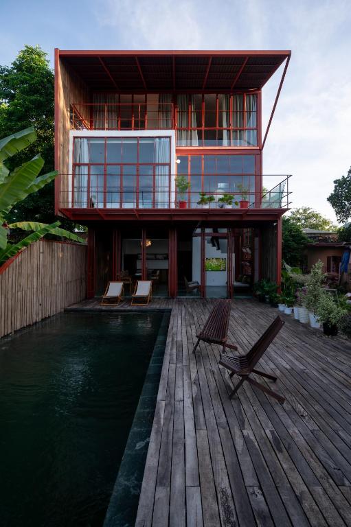 a house on a wooden deck with a swimming pool at Scarlet Pavilion in Thôn An Vân Thượng