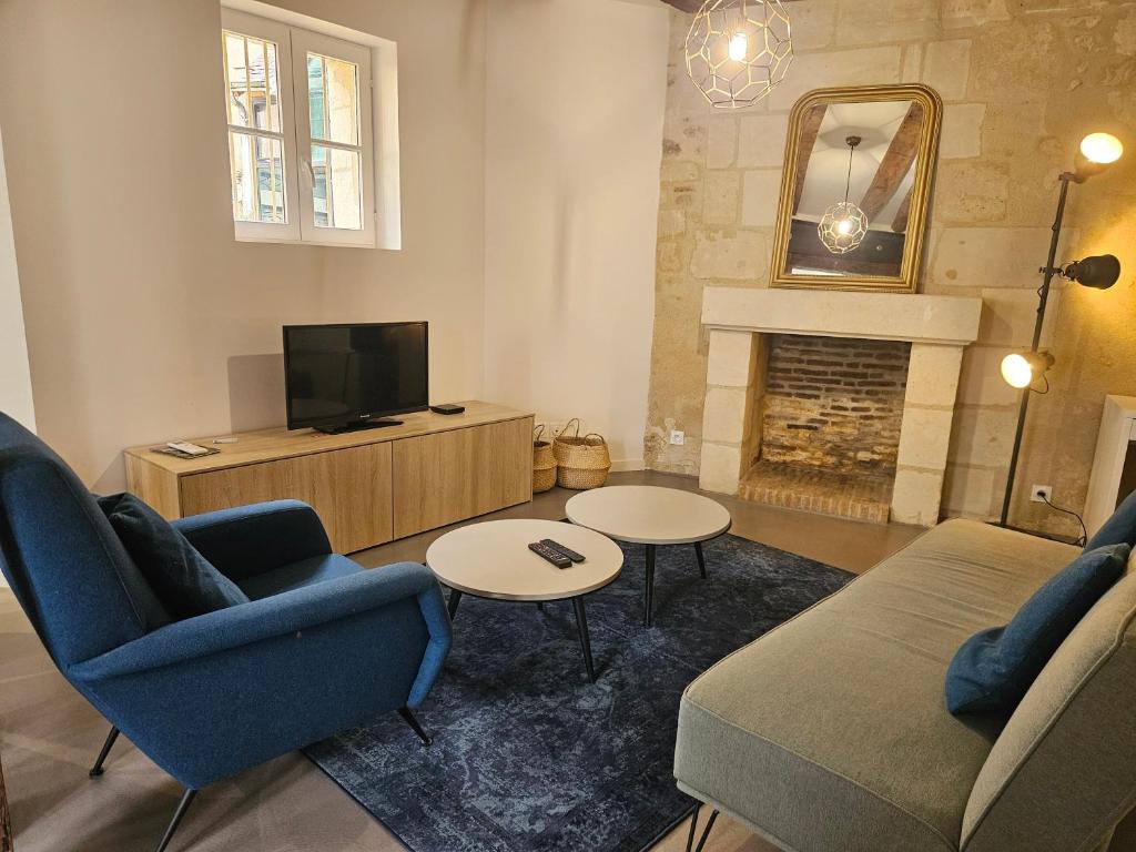 - un salon avec deux chaises, une télévision et une cheminée dans l'établissement Charme & Clim Place Chateauneuf - Coeur de Tours, à Tours