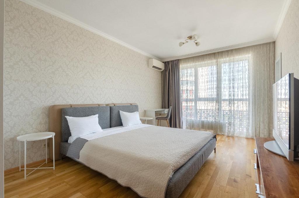a bedroom with a large bed and a large window at Petrovdom Apartments 18-90Б in RC Kvartet, Vasyl Lypkivskyi Street 16B in Kyiv