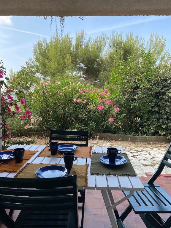 a wooden table with chairs and plates on it at Rez-de-villa dans le calme in Draguignan