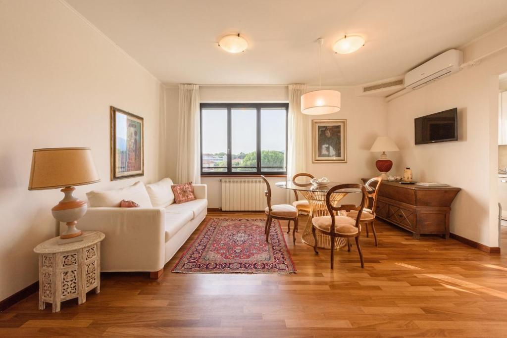 a living room with a white couch and a table at GOLDEN LUXE - Royal Sea View Private Parking in Marina di Pietrasanta