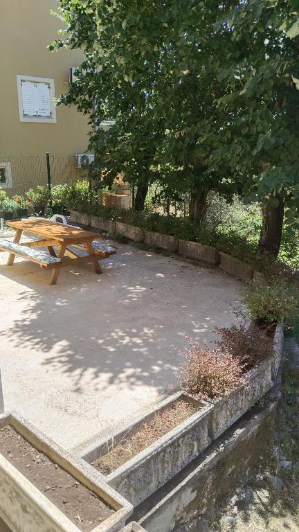 a picnic table in a park next to a tree at Three lindens in Herceg-Novi