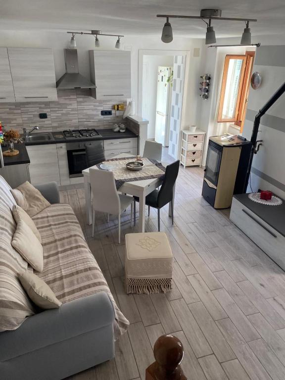 a living room with a couch and a table and a kitchen at La Casetta di Nico in Beverone