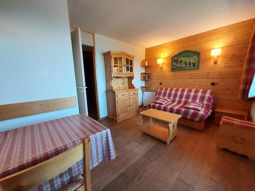 une chambre avec un lit et un canapé dans une pièce dans l'établissement Appart 2P au pied des pistes, animaux admis, Valmorel - FR-1-356-190, à Valmorel