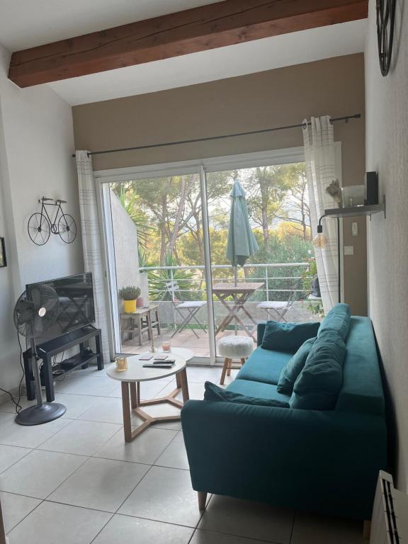 un salon avec un canapé bleu et une table dans l'établissement Appartement duplex la Ciotat, à La Ciotat