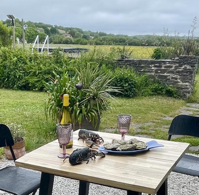 a table with a plate of food and a bottle of wine at Esquinandra - Chambre randonneurs et cyclistes - GR 223 - Quai des Ormes in Barneville-Carteret