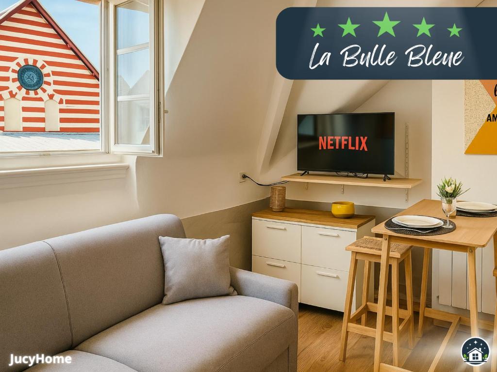un salon avec un canapé et une télévision dans l'établissement La Bulle Bleue, à Berck-sur-Mer