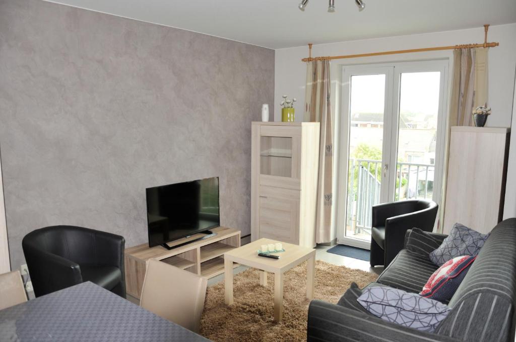 uma sala de estar com um sofá e uma televisão em Apartment Franky em Oostende