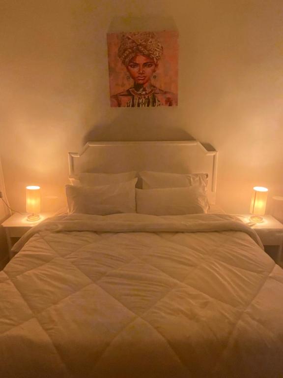 a bedroom with a white bed with two lamps at Doody Cozy chalet in Dahab