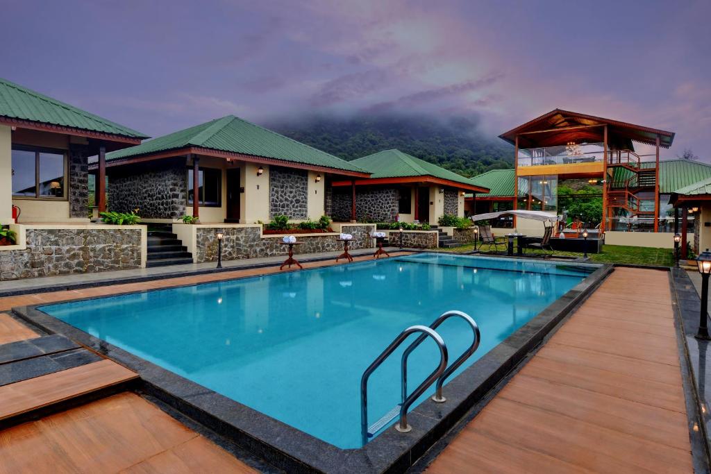 a swimming pool in front of a resort at Alokik Sharanam Zinc Journey by The Fern, Mahabaleshwar in Mahabaleshwar