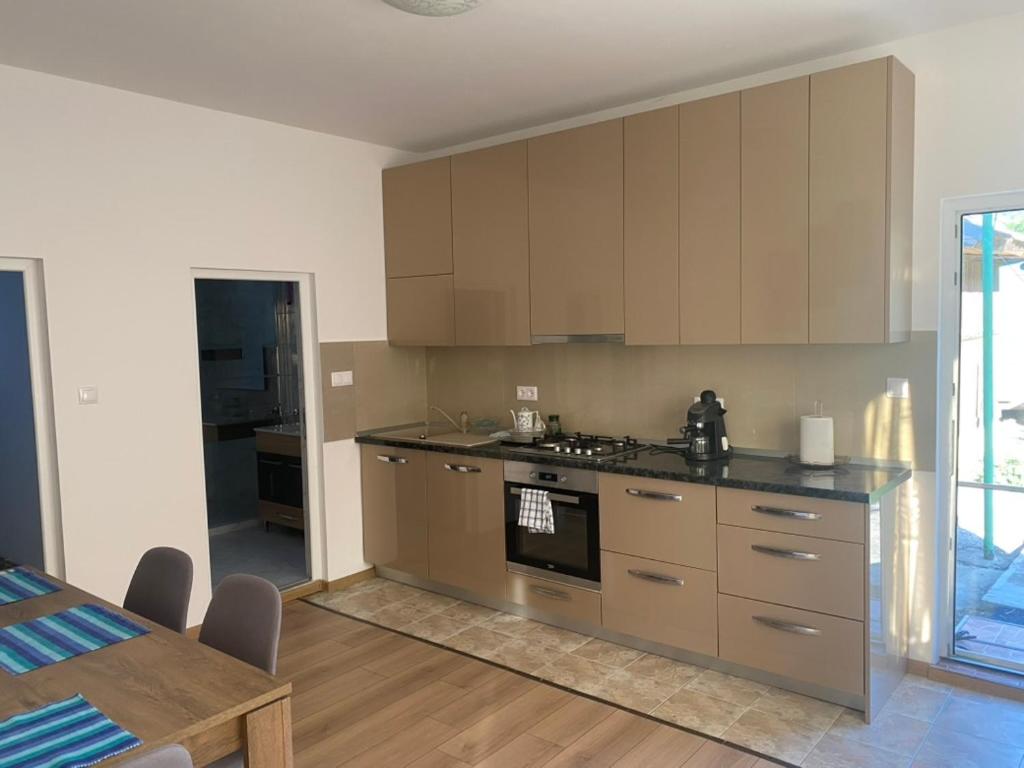 a kitchen with stainless steel appliances and a table at Casa Ani in Ocna-Mureşului