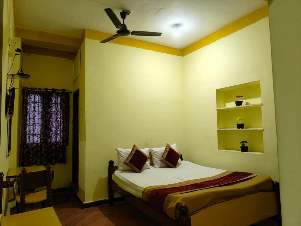 a bedroom with a bed with a ceiling fan at ADH Mysore Nivas in Mysore
