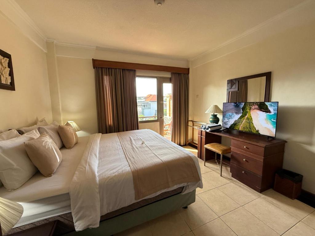 a bedroom with a bed and a dresser with a television at Private Apartment 6503 at the Jayakarta Residence in Seminyak