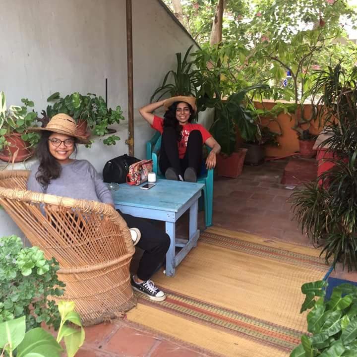 two women in hats sitting on a porch at Villa Butterfly Studio in Pondicherry