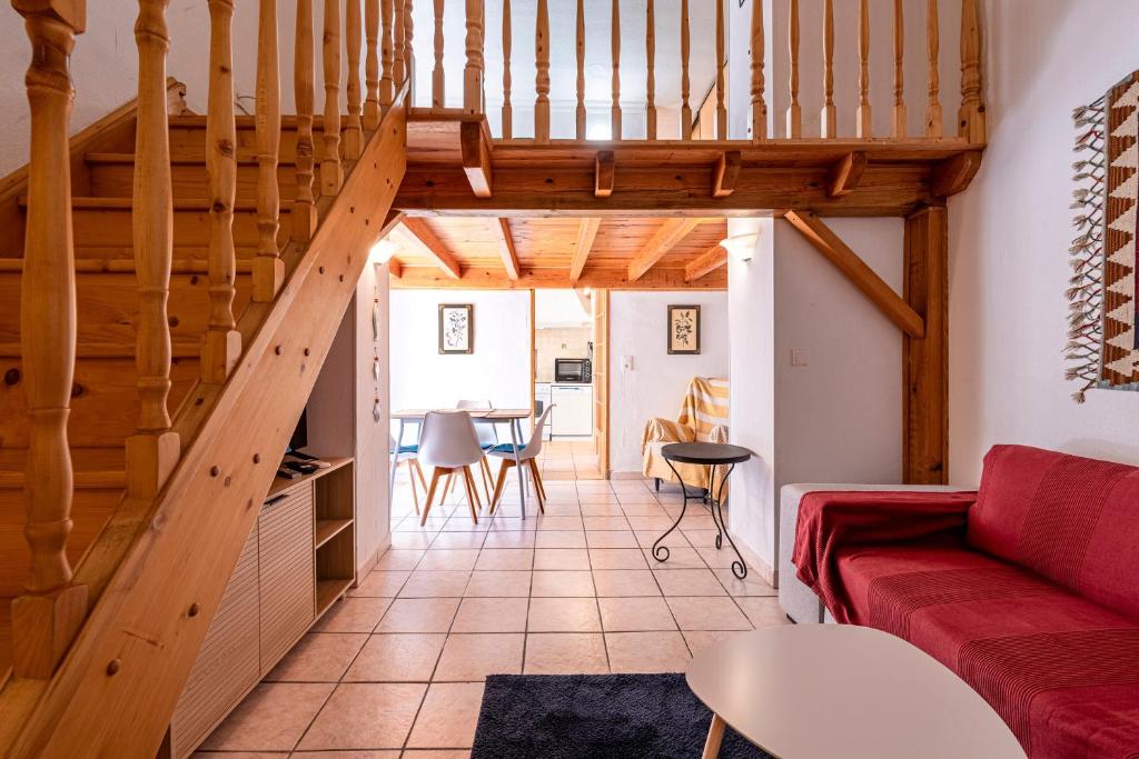 - un salon avec un canapé rouge et des escaliers en bois dans l'établissement Appartement cosy - Hyper centre-ville, à Ajaccio