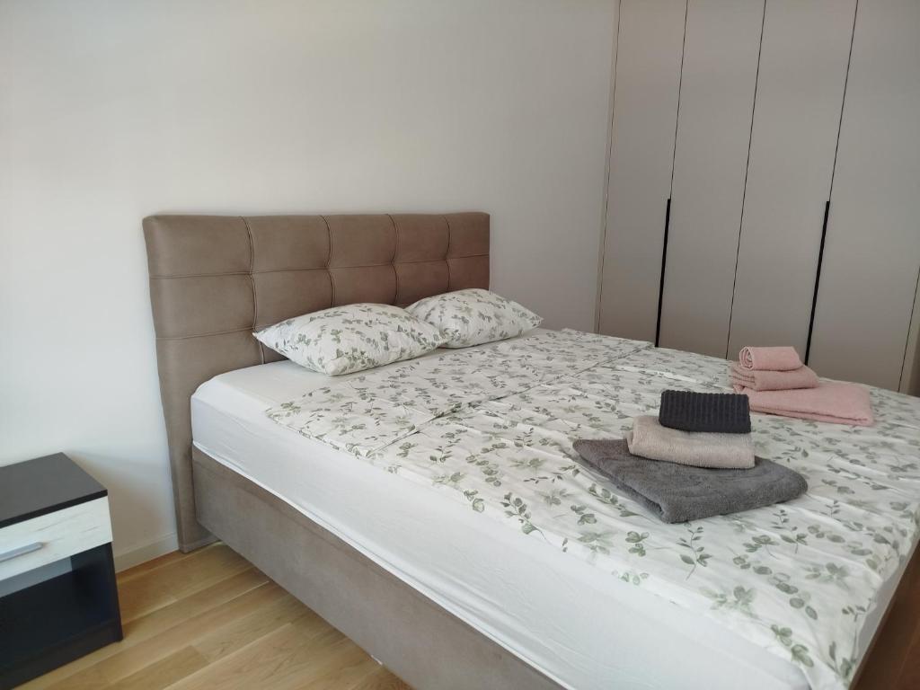 ein Bett mit zwei Kissen und einem Hut darauf in der Unterkunft Dvosoban stan Akacija Trebinje in Trebinje