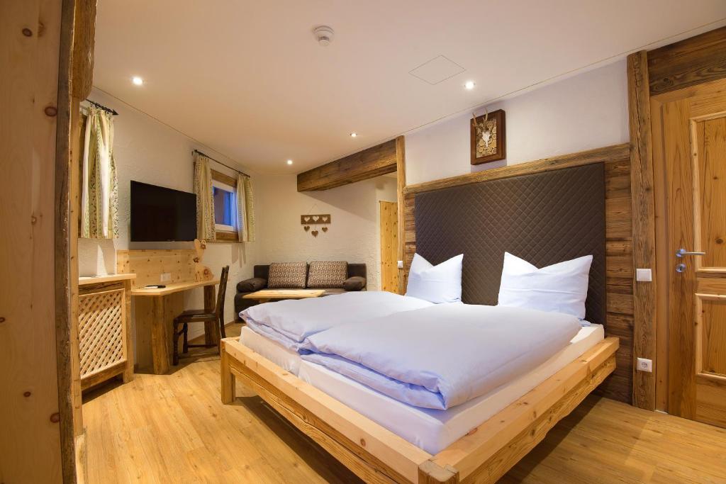 a bedroom with a large bed and a desk at Gipfelhaus Gerlitzen in Arriach