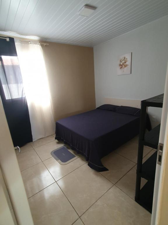 a small bedroom with a bed and a window at Casa de locação in Goiana