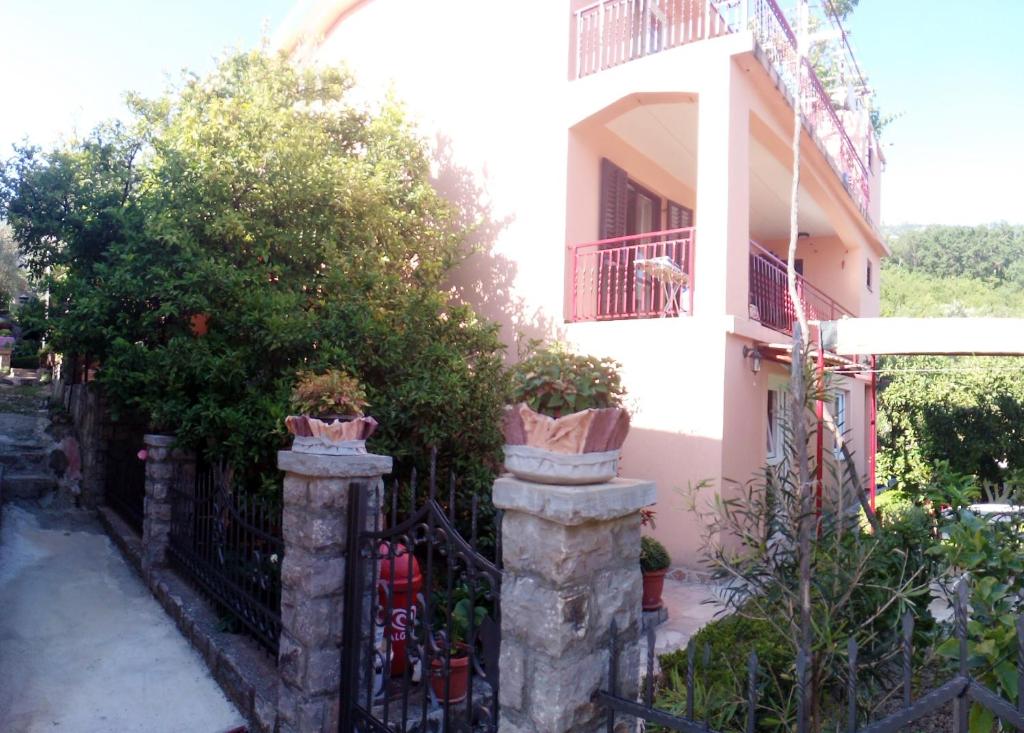 a house with a fence with potted plants on it at Apartments Kovačević in Petrovac na Moru