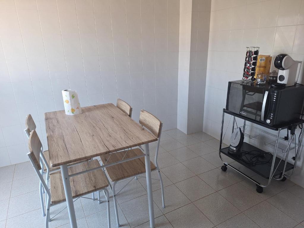 a table and chairs in a kitchen with a microwave at Appartement dans le centre historique in Alliste